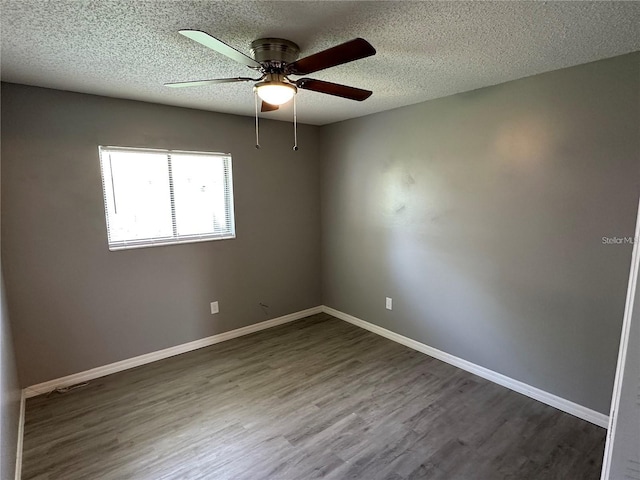 unfurnished room with a textured ceiling, ceiling fan, and dark wood-type flooring