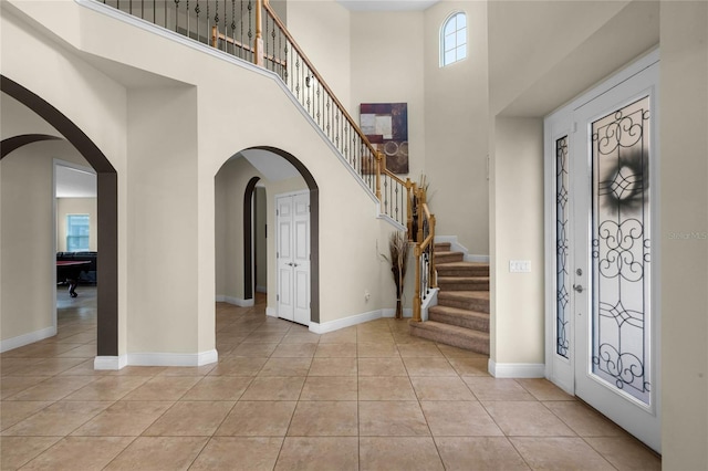 tiled entryway with a high ceiling