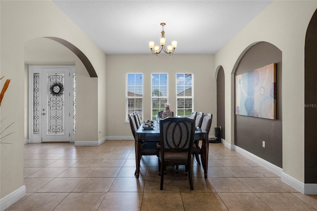 dining space with light tile patterned floors and a chandelier