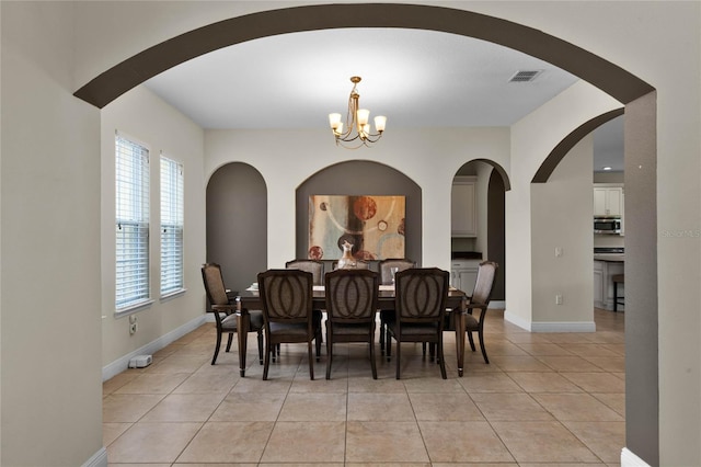 dining room with light tile patterned flooring and a notable chandelier