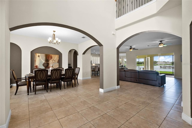 dining room featuring ceiling fan with notable chandelier and light tile patterned floors