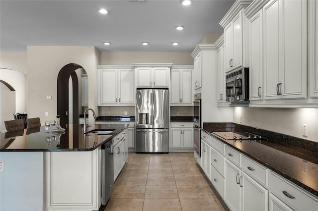 kitchen featuring light tile patterned floors, stainless steel appliances, white cabinets, and sink