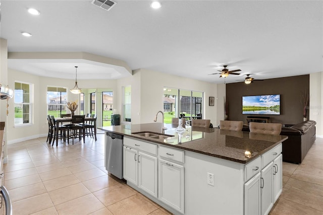 kitchen with white cabinetry, a kitchen island with sink, pendant lighting, stainless steel dishwasher, and sink