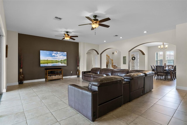 living room featuring light tile patterned floors and ceiling fan with notable chandelier