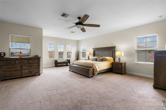 carpeted bedroom with ceiling fan and multiple windows