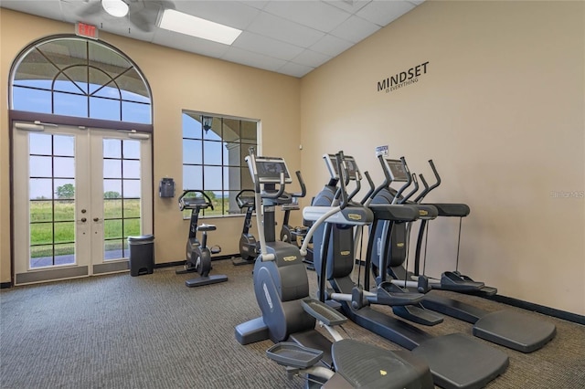 exercise room featuring a paneled ceiling, french doors, and carpet flooring