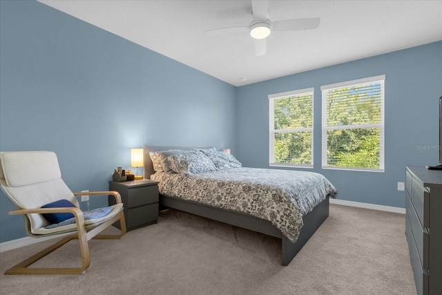 bedroom with light carpet, ceiling fan, and baseboards