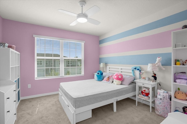 bedroom with ceiling fan, baseboards, and light colored carpet