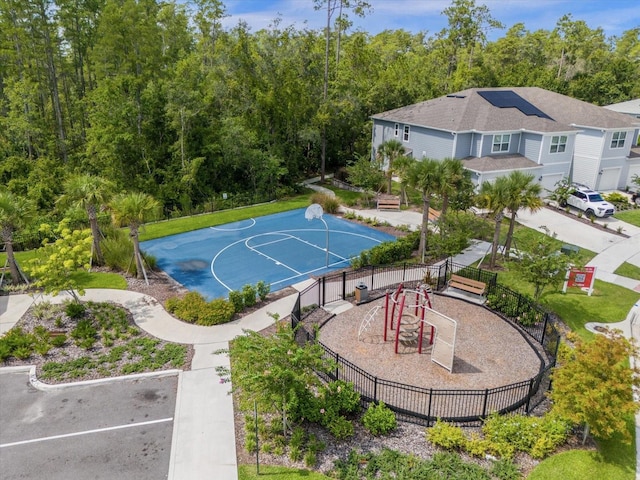 view of sport court featuring community basketball court, fence, and playground community