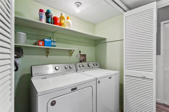 laundry room featuring washing machine and dryer and a textured ceiling