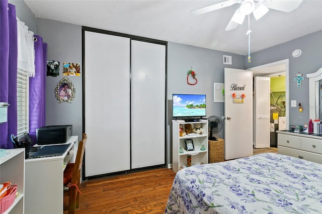 bedroom with wood-type flooring, ceiling fan, a textured ceiling, and a closet