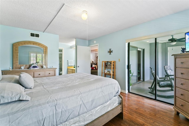 bedroom featuring dark wood-type flooring, a closet, and a textured ceiling