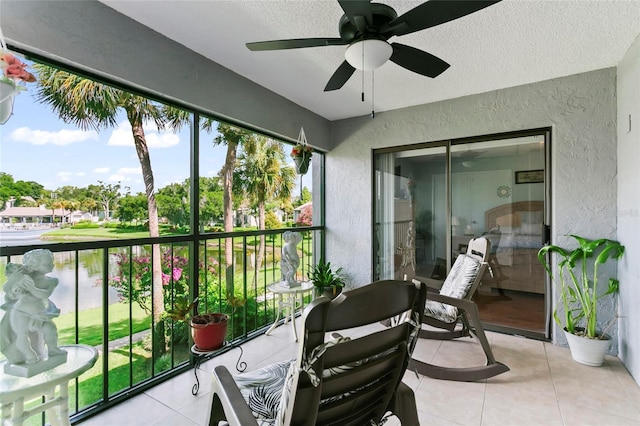 balcony featuring a water view and ceiling fan