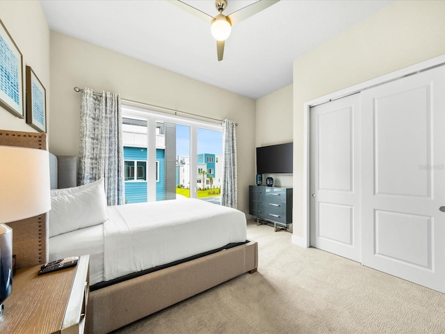 bedroom featuring light carpet, a closet, and ceiling fan