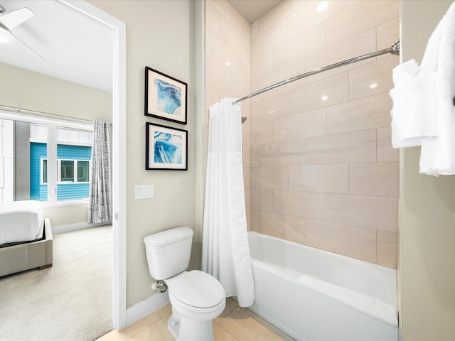 bathroom with tile patterned floors, shower / bath combo with shower curtain, and toilet