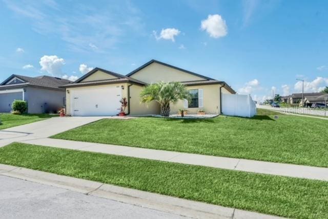 ranch-style home featuring a garage and a front yard