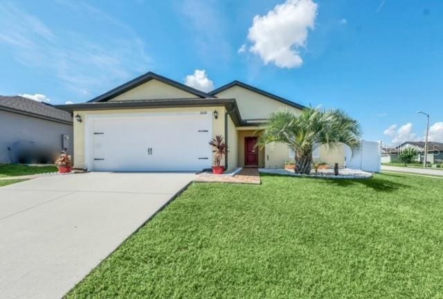 ranch-style house featuring a garage and a front lawn