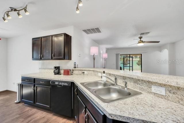 kitchen featuring hardwood / wood-style floors, black dishwasher, sink, dark brown cabinetry, and kitchen peninsula