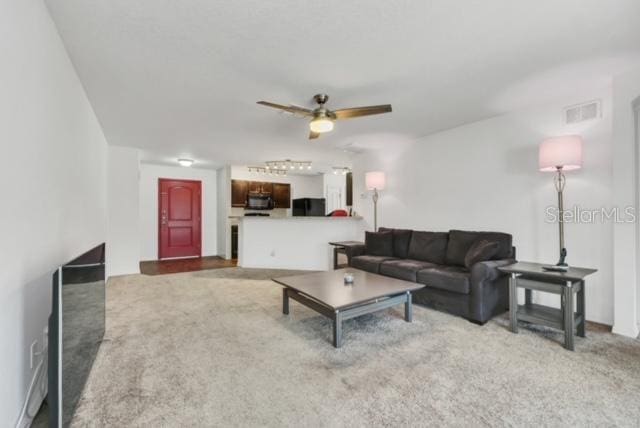 living room featuring carpet floors and ceiling fan