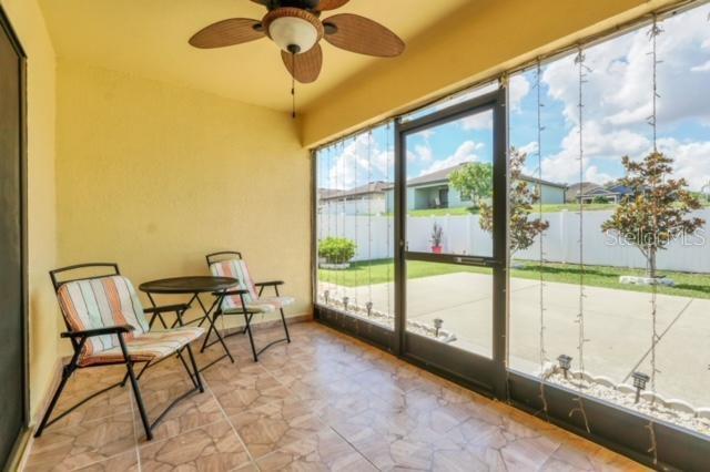 sunroom / solarium featuring a water view and ceiling fan