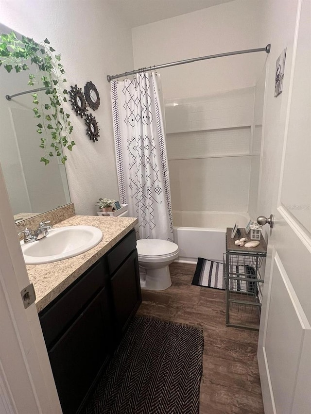 full bathroom featuring wood-type flooring, vanity, shower / tub combo, and toilet