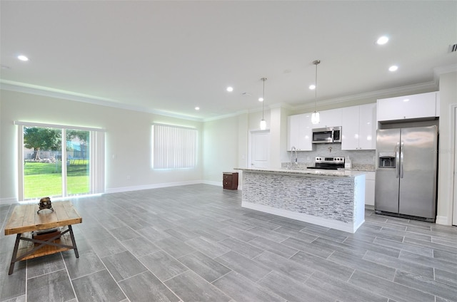 kitchen featuring light hardwood / wood-style flooring, white cabinetry, pendant lighting, an island with sink, and stainless steel appliances