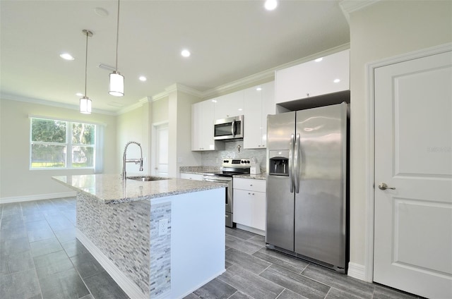 kitchen featuring sink, hanging light fixtures, an island with sink, white cabinets, and appliances with stainless steel finishes