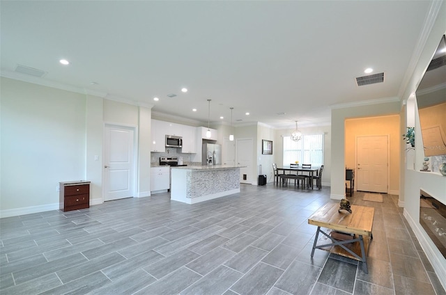 living room with hardwood / wood-style floors, an inviting chandelier, and ornamental molding