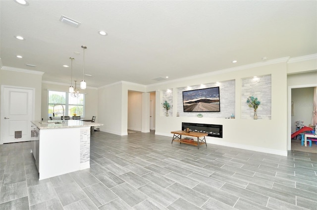 kitchen featuring pendant lighting, sink, light hardwood / wood-style floors, and an island with sink