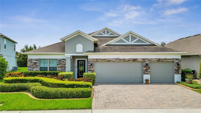 view of front of home with a garage and central air condition unit