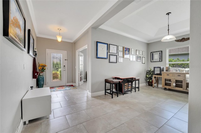 foyer with tile patterned flooring, a tray ceiling, and ornamental molding