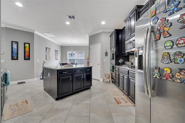 kitchen featuring appliances with stainless steel finishes, decorative light fixtures, light tile patterned floors, a kitchen island, and ornamental molding