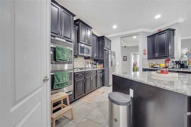 kitchen featuring appliances with stainless steel finishes, tasteful backsplash, light stone counters, light tile patterned floors, and crown molding