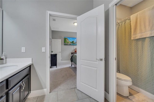 bathroom featuring tile patterned flooring, toilet, and vanity