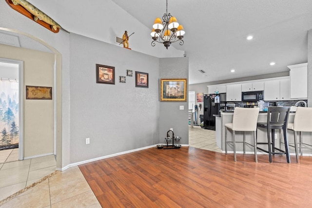 dining room with light tile patterned floors and a chandelier