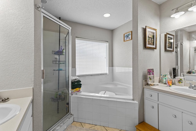 bathroom featuring a textured ceiling, independent shower and bath, tile patterned floors, and vanity