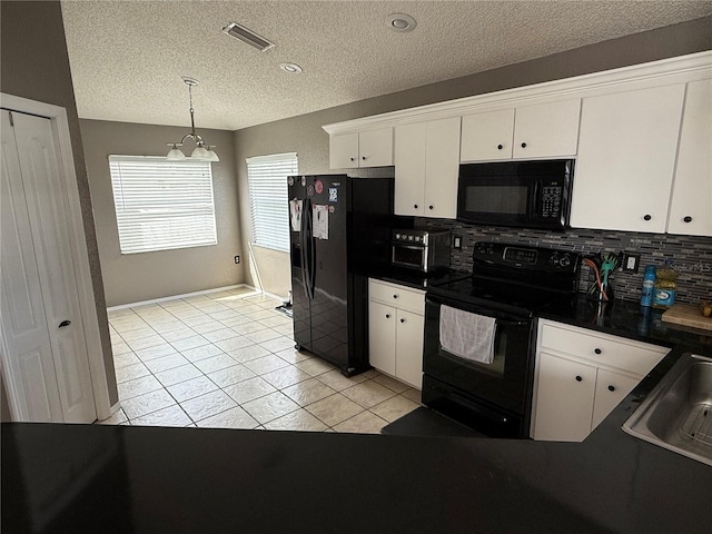 kitchen with hanging light fixtures, white cabinets, black appliances, and light tile patterned flooring