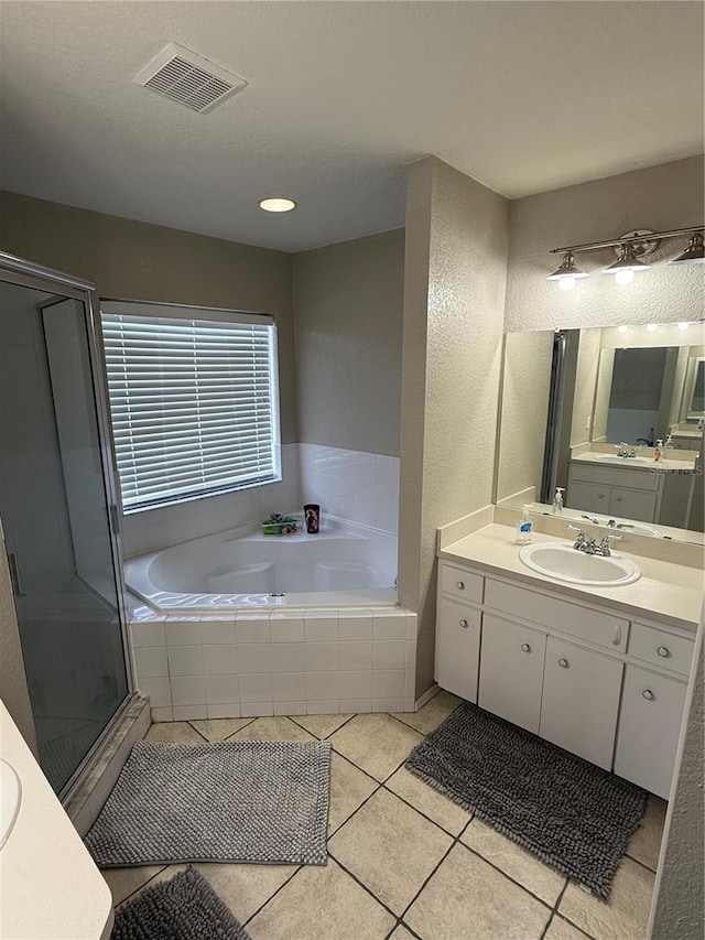 bathroom with plus walk in shower, vanity, and tile patterned flooring