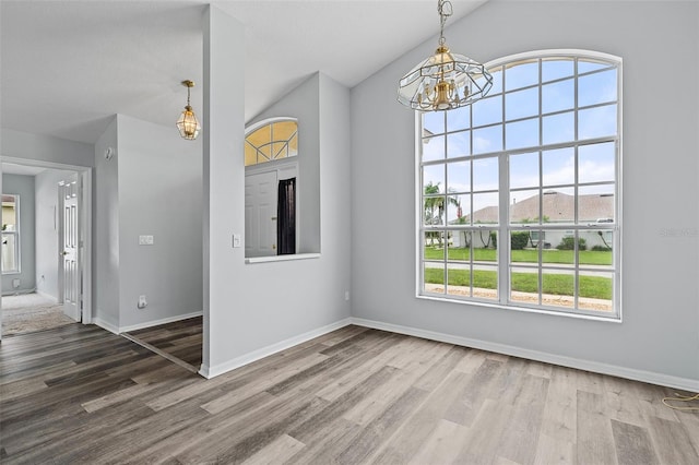 interior space featuring vaulted ceiling, dark hardwood / wood-style floors, and a chandelier