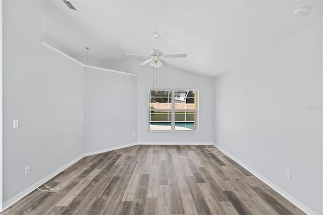 spare room with ceiling fan, a textured ceiling, wood-type flooring, and vaulted ceiling