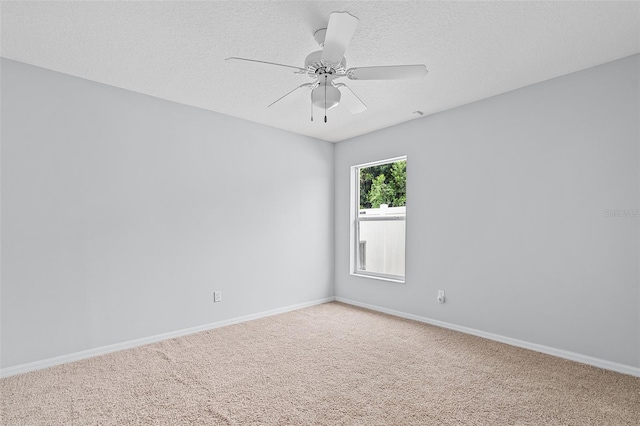 spare room with a textured ceiling, carpet, and ceiling fan