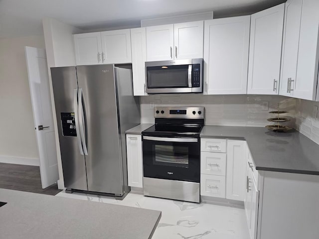 kitchen with appliances with stainless steel finishes, light hardwood / wood-style flooring, white cabinets, and backsplash