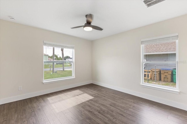 unfurnished room featuring dark hardwood / wood-style floors, ceiling fan, and a wealth of natural light