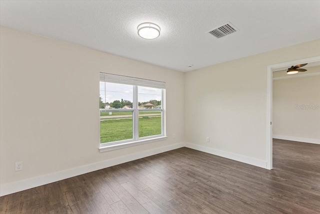 unfurnished room with ceiling fan, a textured ceiling, and dark hardwood / wood-style floors