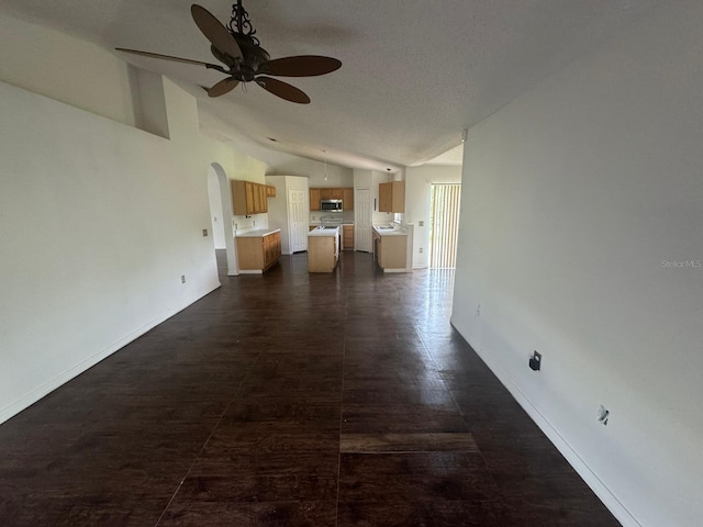 corridor with tile patterned flooring and vaulted ceiling