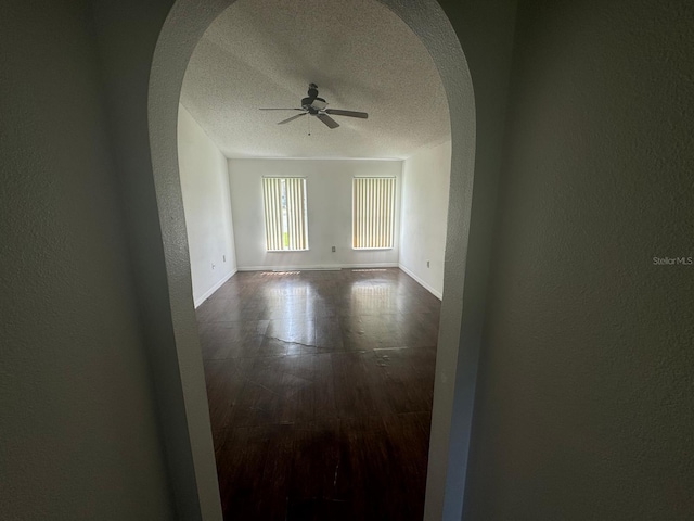 unfurnished room featuring wood-type flooring, a textured ceiling, and ceiling fan