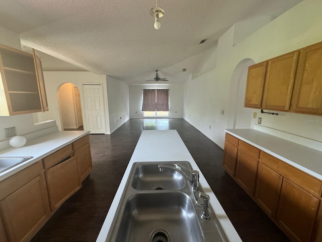 kitchen featuring dark wood-type flooring, sink, a textured ceiling, and ceiling fan