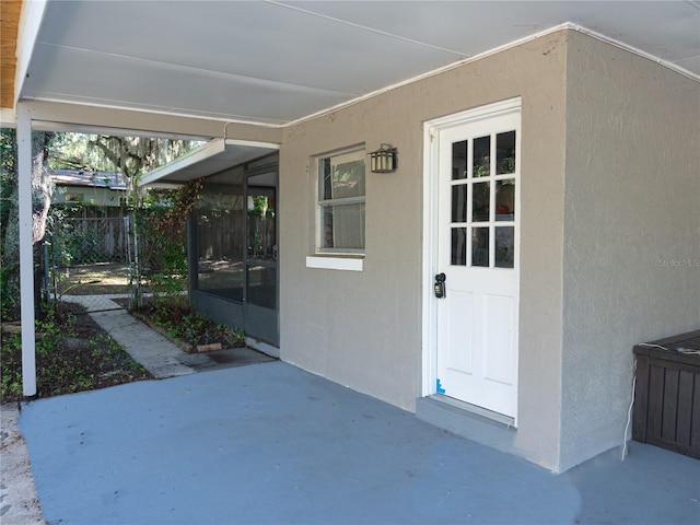 view of exterior entry with a patio area