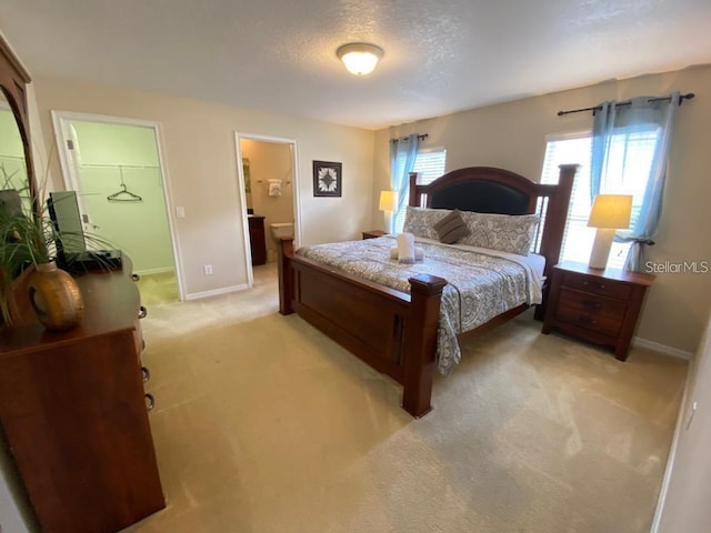 carpeted bedroom featuring connected bathroom and a textured ceiling