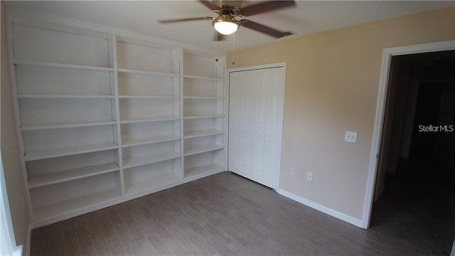 unfurnished bedroom with ceiling fan, dark hardwood / wood-style flooring, and a closet